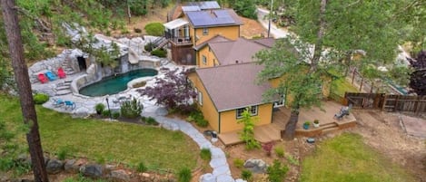 Una casa con piscina, un sendero de piedra y un pequeño jardín.