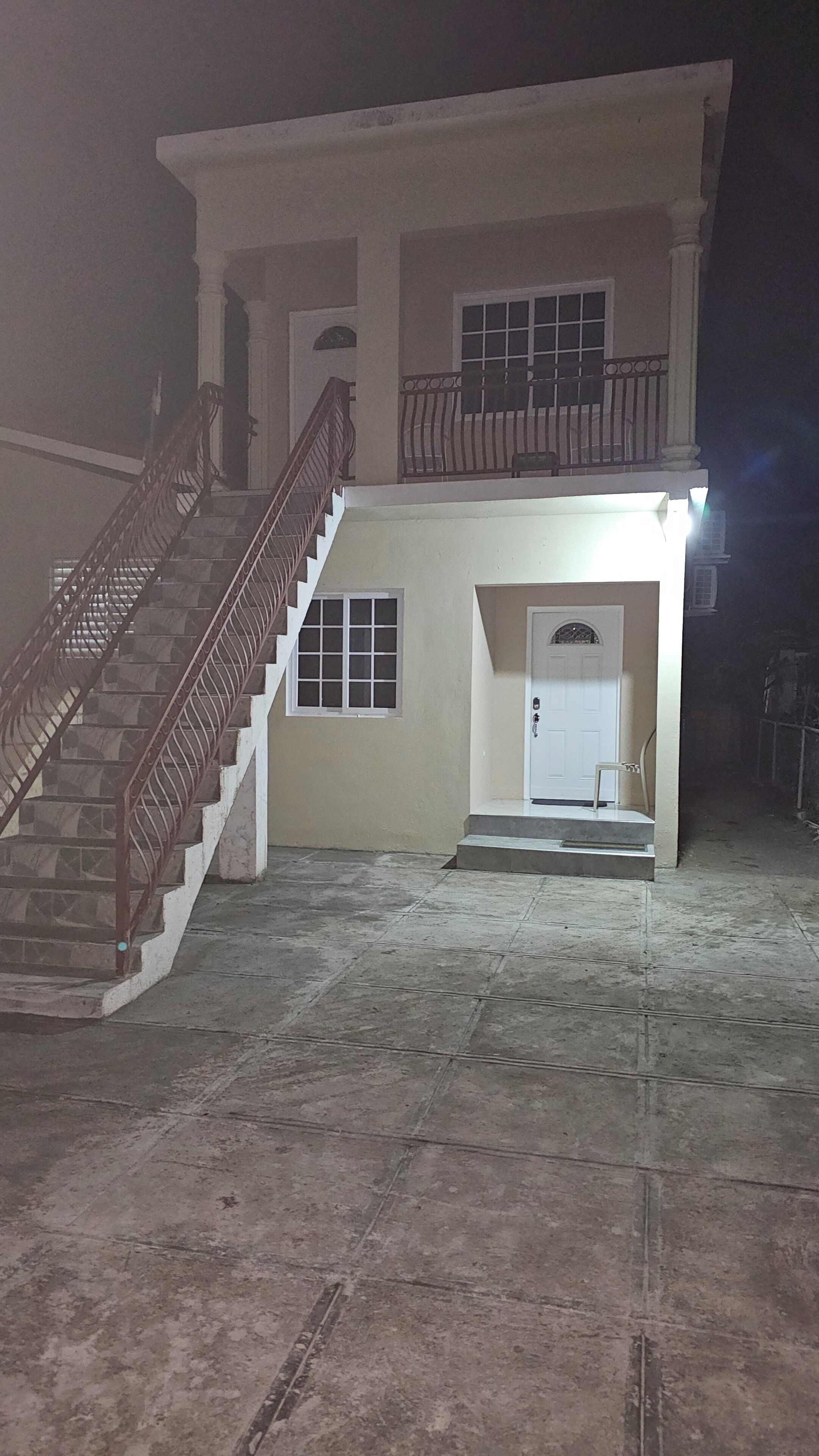 Un edificio a due piani con una scala che conduce al piano superiore.