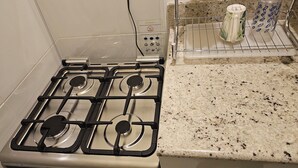 A kitchen with a gas stove, a microwave, and a coffee maker on the countertop. - Tandel Ocho Rios Apartment #1 (Ocho Rios)
