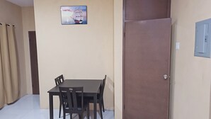 A room with a dining table and chairs, a door, and a wall-mounted picture. - Tandel Ocho Rios Apartment #1 (Ocho Rios)