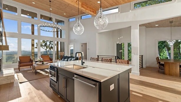 A spacious kitchen with a large island, wooden ceiling, and large windows offering a view of the outdoors. - NEW CONSTRUCTION 4-bedroom with INCREDIBLE VIEWS minutes to Downtown Blue Ridge! (Mineral Bluff)