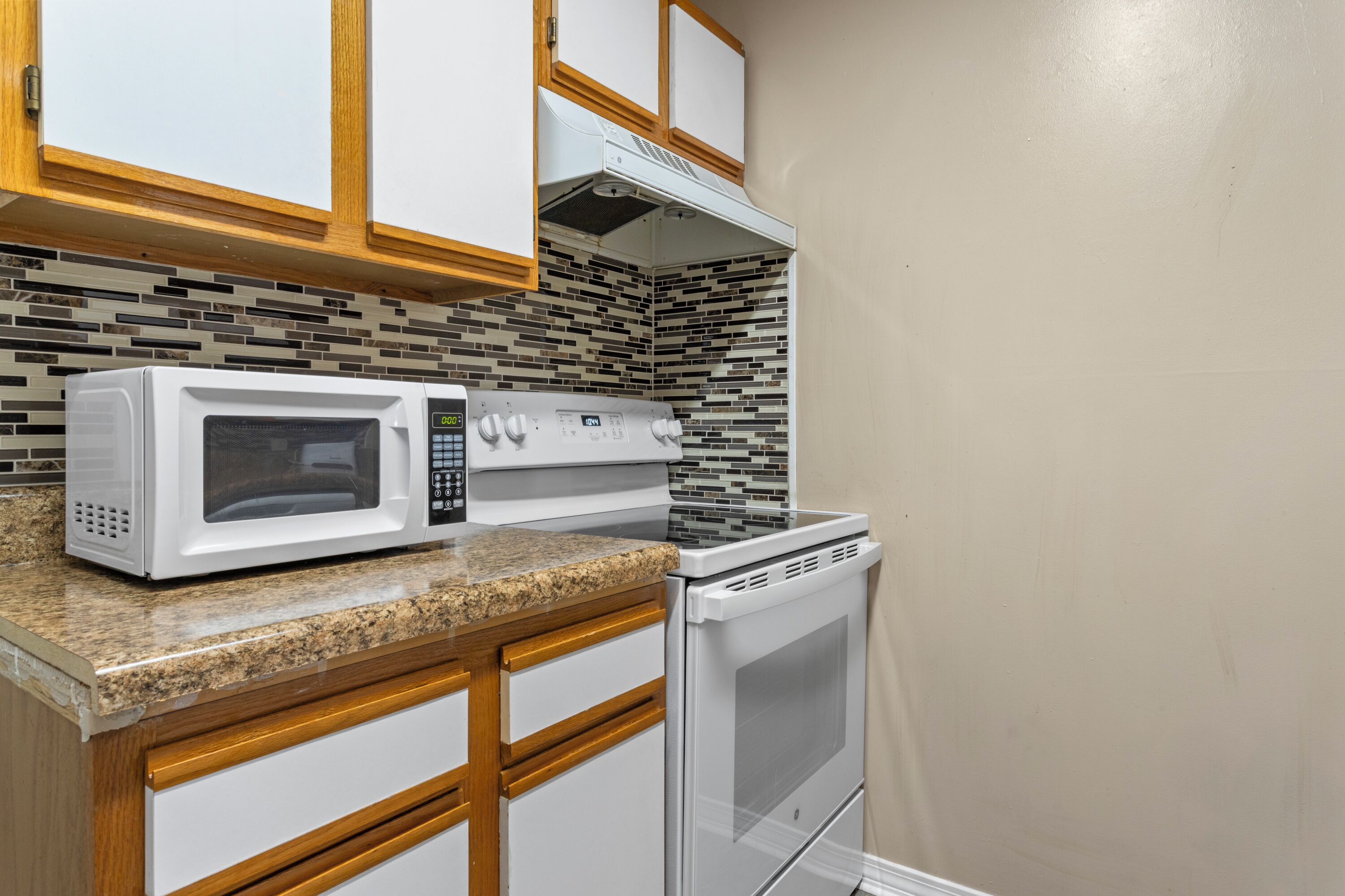 A kitchen with white cabinets, a microwave, a stove, and a dishwasher.