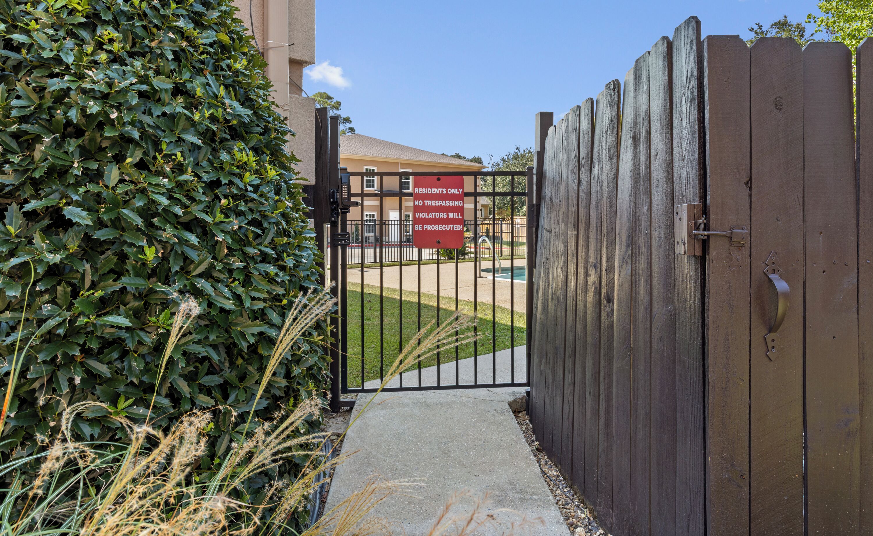A gated entrance with a sign indicating no trespassing for residents.