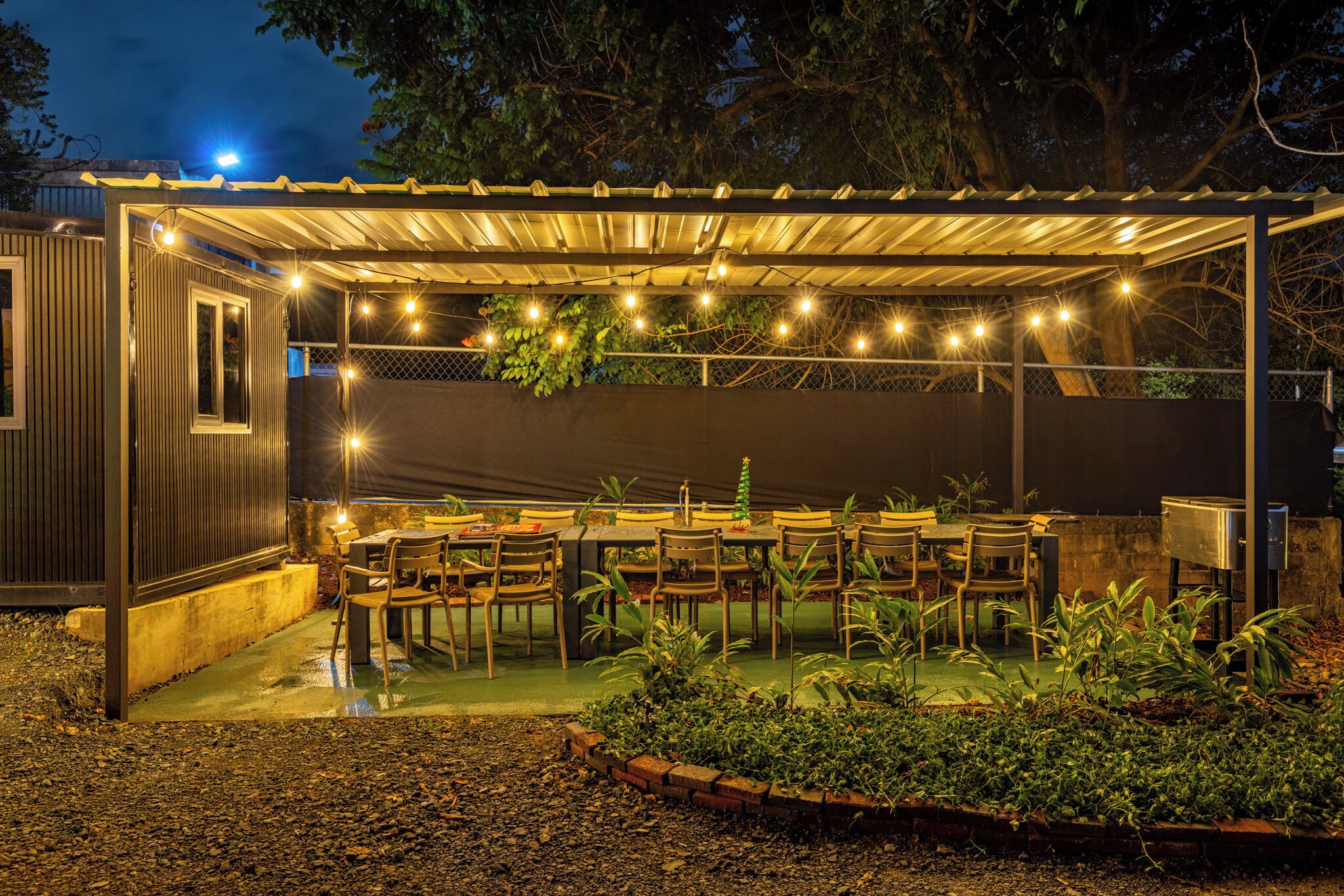 An outdoor patio with string lights, tables, and chairs.