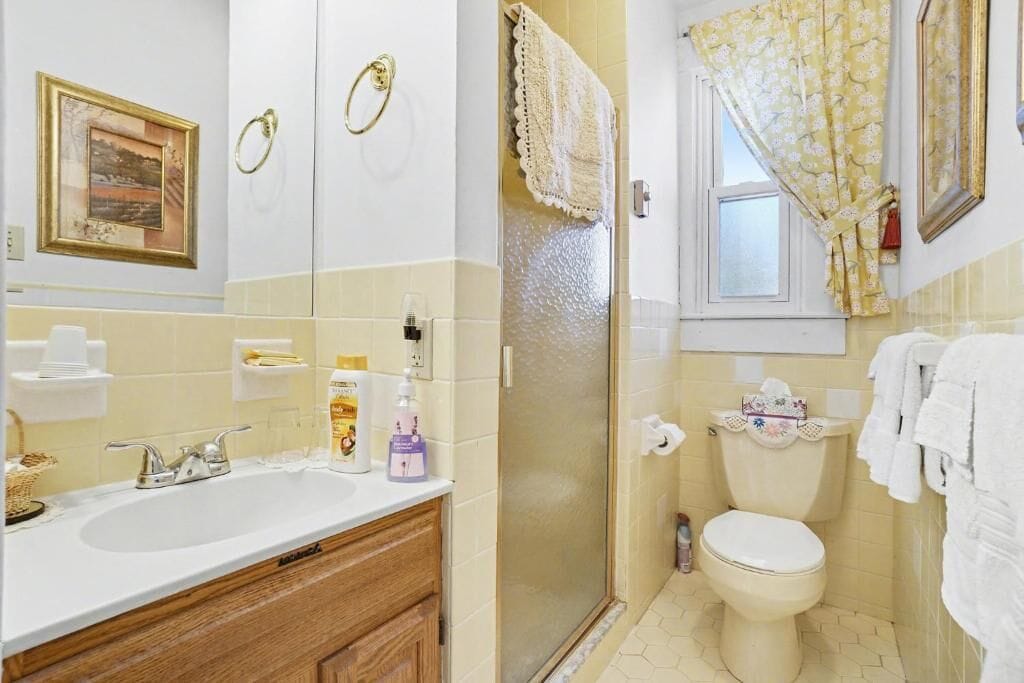 A bathroom with a sink, toilet, and shower. There are towels and toiletries visible.