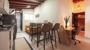Eine moderne Küche mit Herd, Kühlschrank und Essbereich mit Stühlen und Tisch.