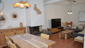 Un ampio soggiorno con tavolo da pranzo in legno, divani e televisione.