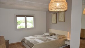 Una camera da letto con un letto, un comodino e una finestra.