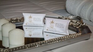 A tray with two business cards and three candles on a reflective surface. - Rey Palace (Cajamarca)