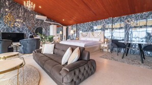 Un dormitorio moderno con una cama grande, un sofá, un televisor y un comedor.
