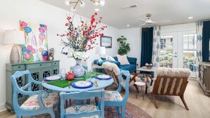 A dining area with a round table, chairs, a vase with flowers, and a ceiling fan. - Modern Upgrades & Comfort (Oxford)