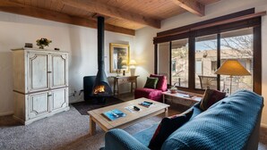 Una sala de estar acogedora con chimenea, un sofá, una mesa de centro y un armario.