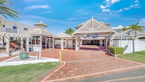 A hotel entrance with a covered walkway, a sign reading "Shoreline," and a number "104" sign. - Shoreline Apartments - Unit 4a (Bargara)
