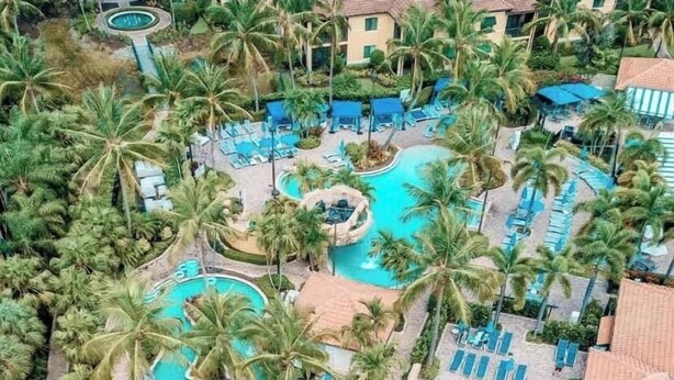 Un complexe hôtelier doté de plusieurs piscines, de palmiers et d’espaces de détente.