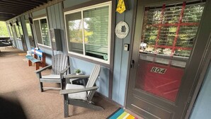 Eine Reihe aus Holztischen und -stühlen vor einem Gebäude, an dem eine Tür mit der Aufschrift '804' angebracht ist.