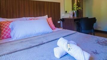 A hotel room with a bed, a desk, a chair, a mirror, and a picture of the Eiffel Tower on the wall.