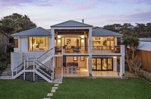 A two-story house with a covered patio, a staircase, and a well-maintained lawn. - Panoramic Ocean Views | N. Avoca, Sleeps 10 (North Avoca)