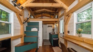 A cabin interior with a wooden staircase, a kitchen area, and a seating space. - Amazing TinyHome on private 48Acres in Massanutten (McGaheysville)