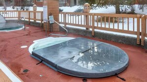 Area idromassaggio con una terrazza in legno e una ringhiera in metallo.