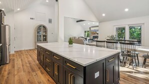 Un'ampia cucina con un'isola grande, pensili in legno e piano cottura integrato.