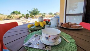 Ein Tisch mit einer Tasse, Zitronen, einem Gebäckteller und einer dekorativen Matte.