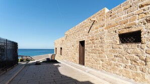 Un bâtiment en pierre avec le chiffre « 7 » peint sur le mur, une porte et une fenêtre.