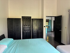 Een kamer met een bed, twee kasten en een kleine tafel met stoelen.