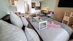 A modern living room with a sofa, a coffee table, and a dining area with chairs. - Nicole inkl. Schwimmbad und Sauna by Interhome (Sankt Englmar)