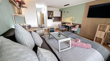 Ein modernes Wohnzimmer mit einer Couch, einem Couchtisch und einem Essbereich mit Stühlen.