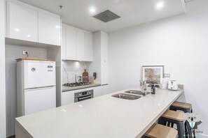 Fridge, oven, stovetop, cookware/dishes/utensils - KozyGuru | Mascot | Stylish 2BR | Balconyand Parking (Mascot)