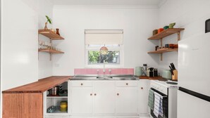 A kitchen with white cabinets, a wooden countertop, a window with a view, and a sink. - Yesterdaze - 5 North Tce, Port Elliot (Port Elliot)