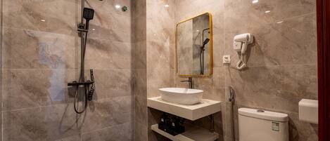 A modern bathroom with a shower, sink, and toilet.