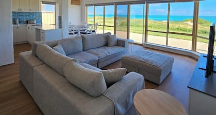 Beachfront retreat with breathtaking views steps from the shore.