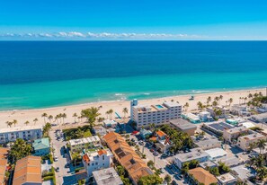 An aerial view of a coastal town with a beach, palm trees, and buildings with flat roofs. - Beach House on the Beach for 8 People With Jacuzzi (Hollywood)