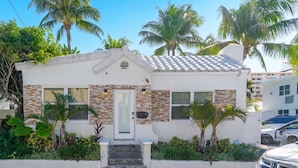 A small, single-story house with a tiled roof, a front door, and a small porch. - Beach House on the Beach for 8 People With Jacuzzi (Hollywood)