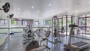 A gym with various exercise equipment, large windows, and a clean, modern design. - Beira Mar Apartment - Fortaleza (Fortaleza)