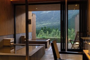 Een modern interieur met houten lambrisering, een zithoek met uitzicht op een bergachtig landschap.