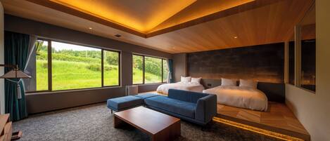 A modern bedroom with a large bed, a blue sofa, and a wooden coffee table.