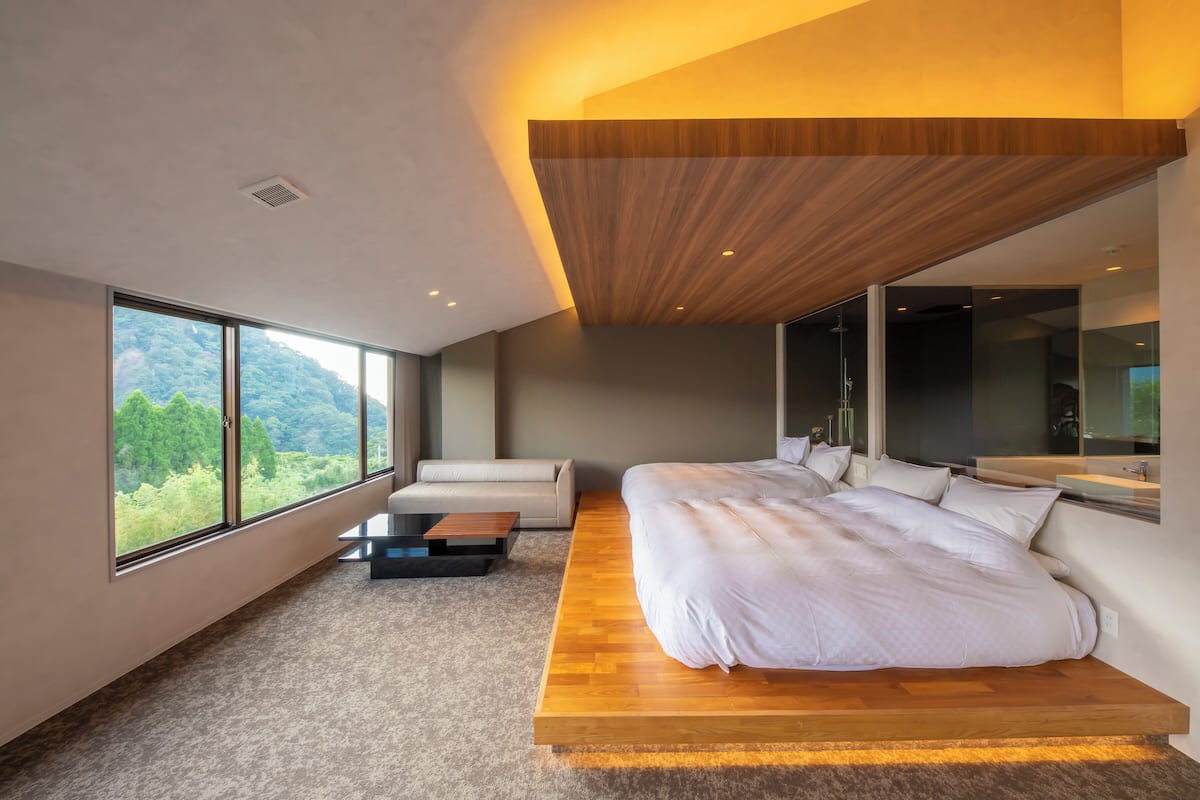 Une chambre moderne avec un grand lit, un canapé et une table basse.