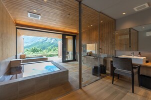 Un baño moderno con cabina de ducha de vidrio, techo de madera y vistas a un paisaje montañoso.