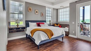 A bedroom with a bed, a ceiling fan, and a view through a door. - Stay & Play! Right next to SDC + Waffles, Games, Hottub, Pool, Outdoor Movies! (Branson)