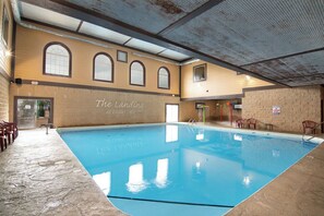 Ein Hallenbad mit einer klaren, blauen Wasserfläche, einem Steinboden und einer Wand mit dem Schriftzug "The Landing at Eagles Nest".