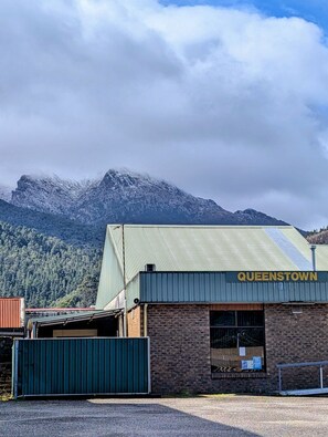 Un edificio con un cartello che riporta 'QUEENSTOWN' e una montagna sullo sfondo.
