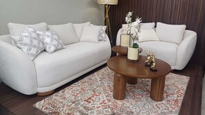 A modern living room with a white sofa, a wooden coffee table, and a patterned rug. - Safe and relaxed apartment 10 minutes from Cuenca's city center (Cuenca)