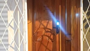 A wooden door with a keypad lock, a small window, and a white lattice fence. - Safe and relaxed apartment 10 minutes from Cuenca's city center (Cuenca)