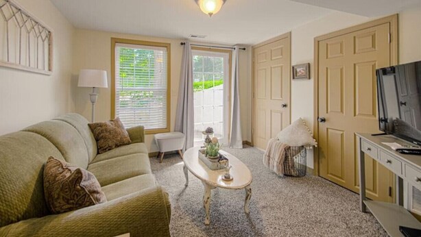 A living room with a sofa, a coffee table, a TV, and a door.