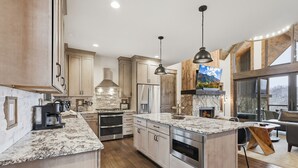A modern kitchen with granite countertops, stainless steel appliances, and wooden cabinetry. - 3BR LUX Cabin w Firepit, Game Loft + Scenic Views! (Banner Elk)