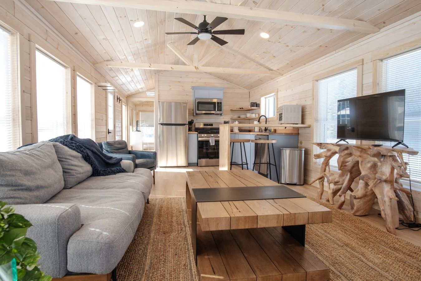 A modern interior with a sofa, coffee table, and a TV on a wooden stand.