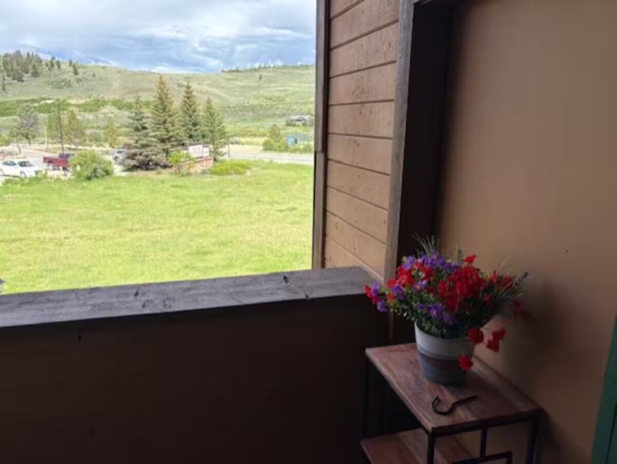 A room with a wooden window sill and a small table with a potted plant.