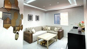 A modern living room with a sofa, coffee table, and decorative mirrors.